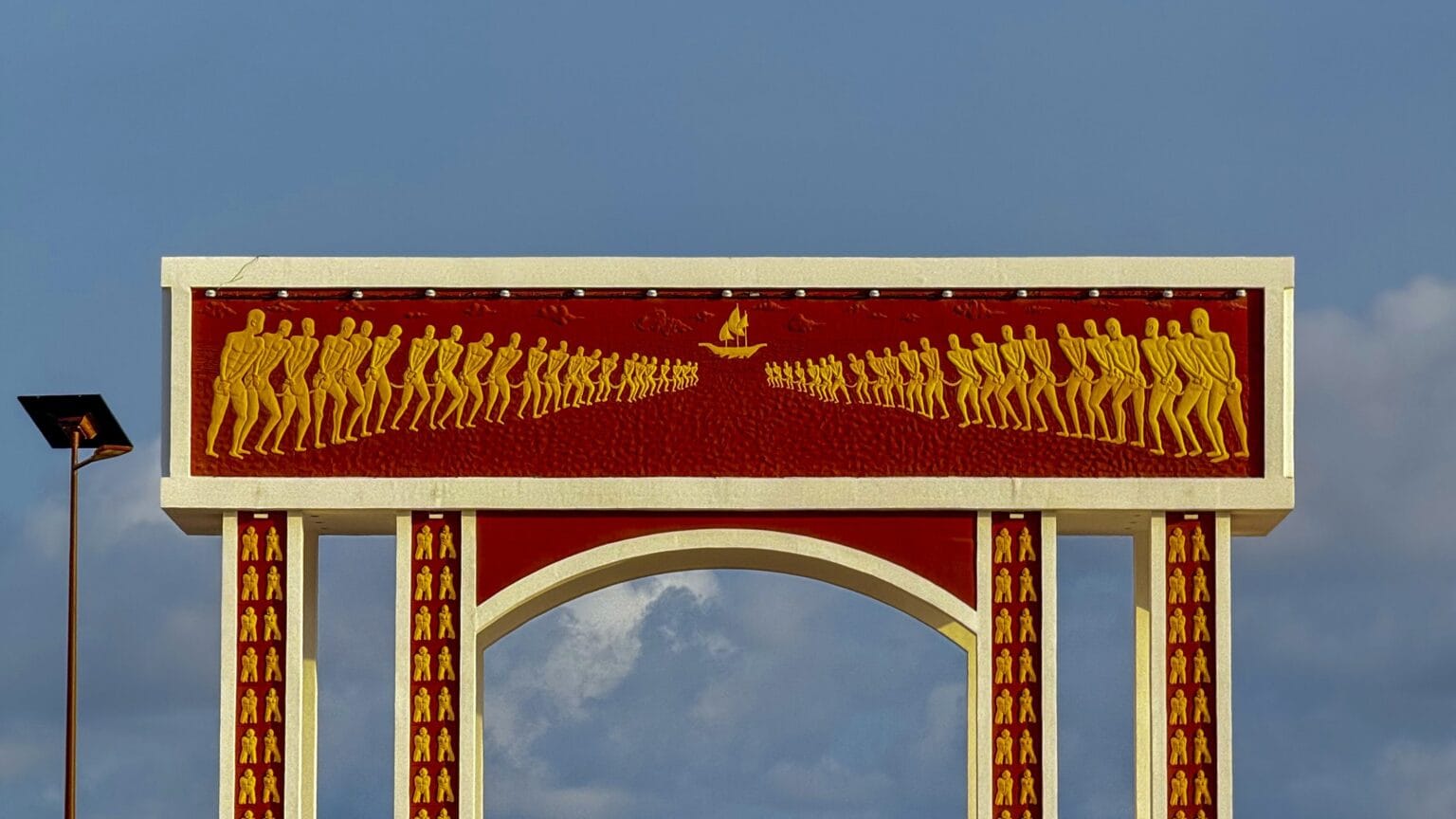 The Door of No Return memorial arch at Ouidah, bas-reliefs of chained captives facing the Atlantic